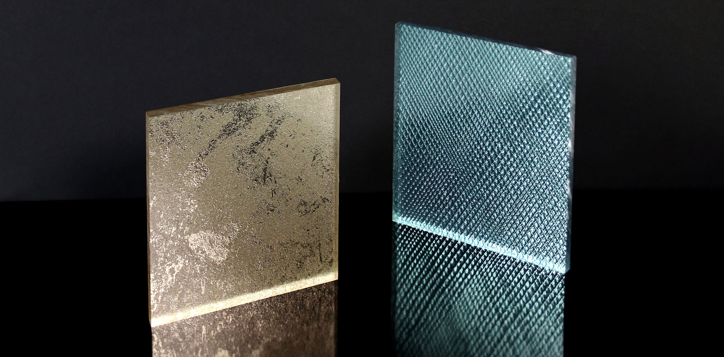 Two square Resin Panel samples, one gold and one turquoise, stand on a reflective surface.