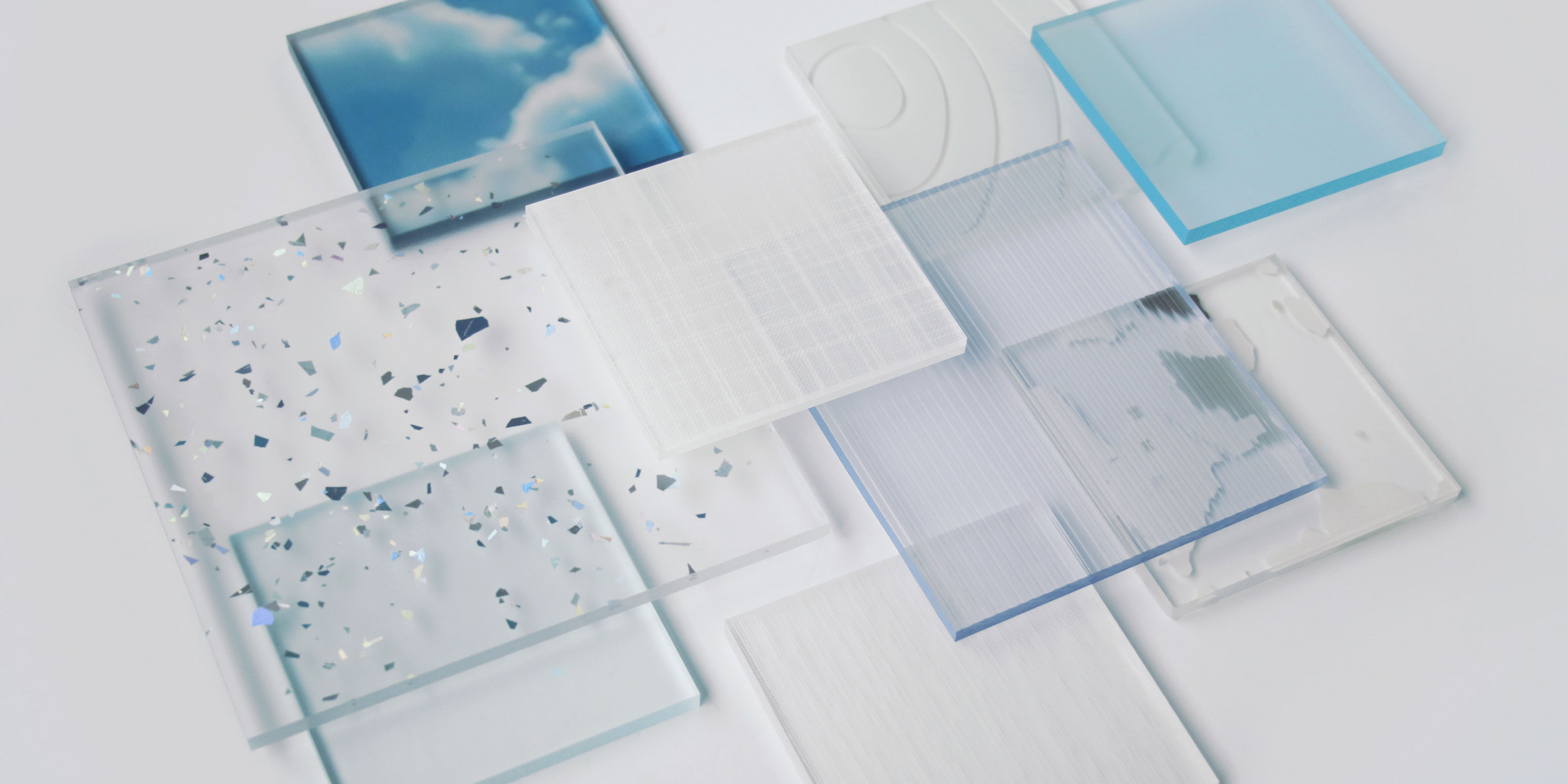 Resin samples of varying sizes, patterns, and colors are layered on top of each other in an asymmetrical composition.