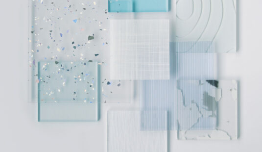 Resin samples of varying sizes, patterns, and colors are layered on top of each other in an asymmetrical composition.