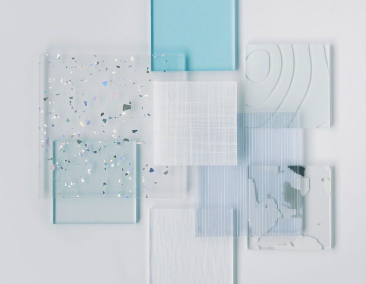 Resin samples of varying sizes, patterns, and colors are layered on top of each other in an asymmetrical composition.