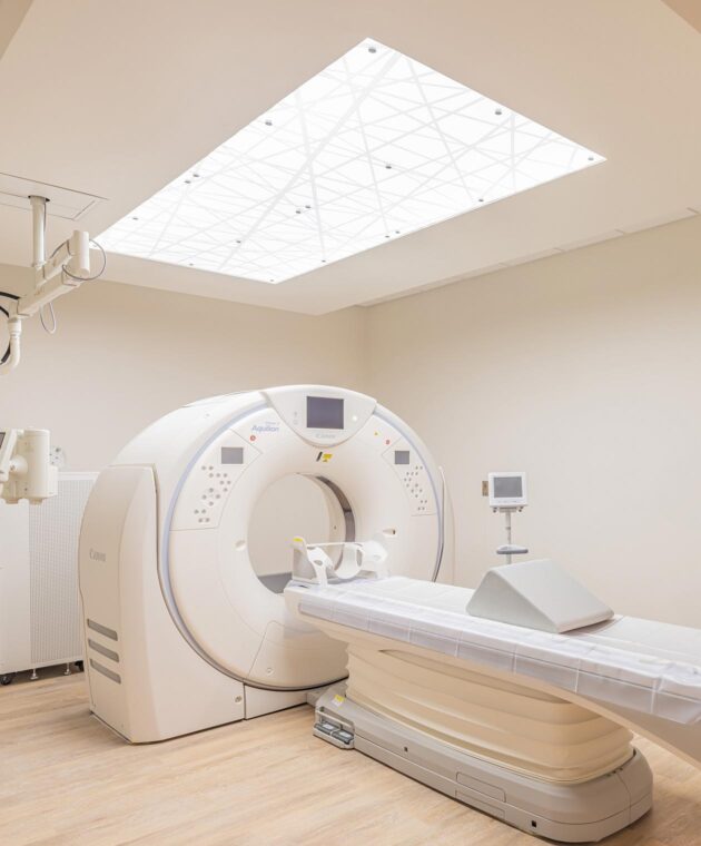 Medical imaging exam room features white rectangular ceiling light secured in place with standoffs.