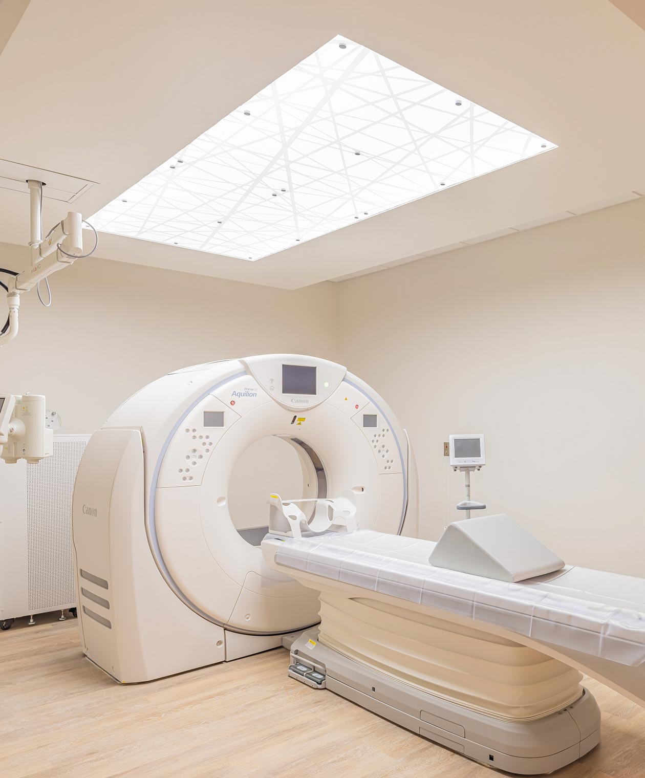 Medical imaging exam room features white rectangular ceiling light secured in place with standoffs.